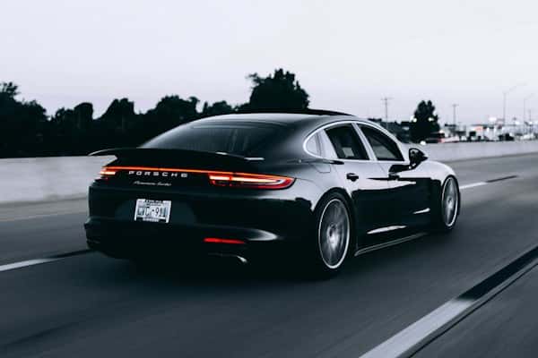 Voiture de sport noire roulant à vive allure sur une route